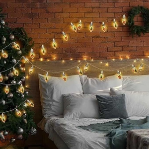 Detail of warm white LED bulb with a mini Christmas tree ornament for indoor decoration