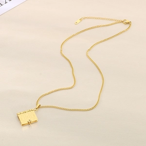 Collier doré en acier inoxydable avec pendentif livre et gravure sur tissu beige
