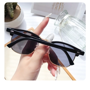 Close-up of classic black and gold Clubmaster style sunglasses with retro rivets