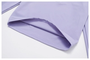 Close-up of double-needle hem stitching and smooth fabric on purple yoga top