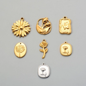 Detailed flat lay of golden and silver floral steel charms for DIY jewelry making