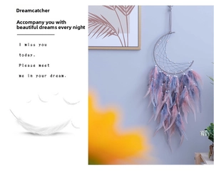 Detail of moon-shaped dreamcatcher with pink gradient feathers and pearl accents