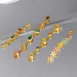 Detailed view of four assorted gold-plated pendants with colorful zircon gemstones