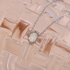 Makroaufnahme von ovalem Opal-Anhänger mit Zirkon-Halo und silberner Halskette