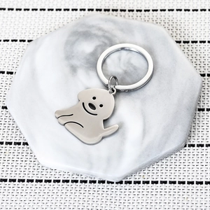 Minimalist silver stainless steel dog pendant keychain on marble coaster base