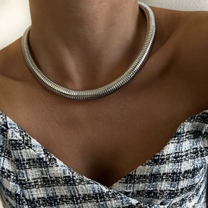 Minimalist silver spring snake bone chain choker necklace worn by a fashion model