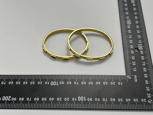 Détail de deux bracelets en acier inoxydable plaqué or 18k avec gemmes vertes et blanches
