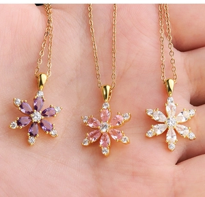 Detailed macro view of a gold snowflake necklace with colorful pear-cut zircon stones