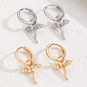 Detail of dragon-shaped hoop earrings in gold and silver finish with crystal accents
