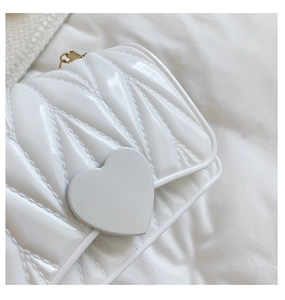 Detail of white heart-shaped silicone crossbody bag with V-shaped quilted texture