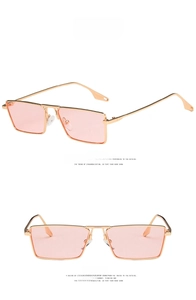 Detail view showing golden metal square frames and pink translucent lenses of sunglasses