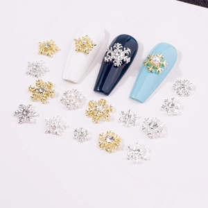Macro shot of gold and silver alloy snowflake nail charms with pearl and rhinestone accents