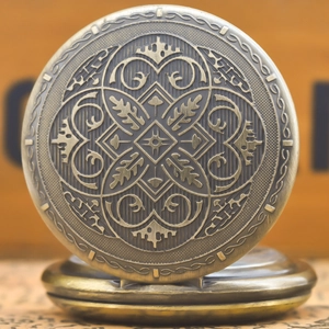 Macro detail of vintage bronze quartz pocket watch featuring intricate floral relief patterns