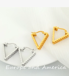 Detailed view of silver and gold triangular earrings with scalloped textured edges