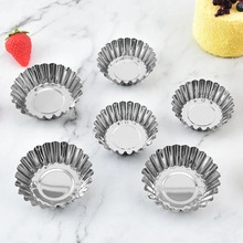Detailed top view of stainless steel egg tart molds on a white marble background
