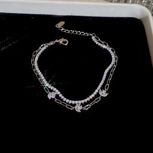 Detail of silver double-layer bracelet with sparkling zircon leaves on black background
