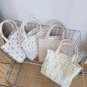 Quilted floral tote bags with diamond stitching and simple wish label in a cart