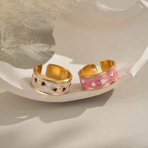 Evil eye open rings in pink and white enamel on a minimalist plaster tray