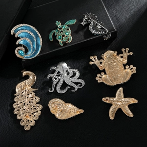 Sparkling rhinestone animal brooches including turtle and peacock on black background