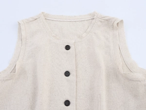 Detailed macro view of the frayed edges and button closure on beige linen vest