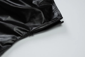 Vue détaillée d'un haut en cuir PU noir brillant avec une fermeture éclair latérale en métal