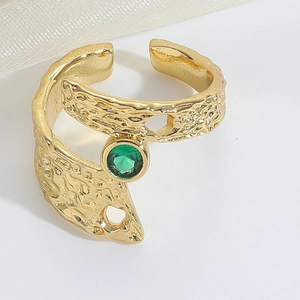 Detail of adjustable gold ring with irregular hammered texture and green gemstone