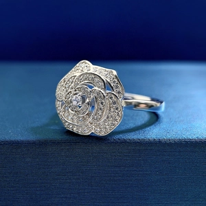 Macro shot of silver camellia ring featuring micro-pave stones and a central gem detail