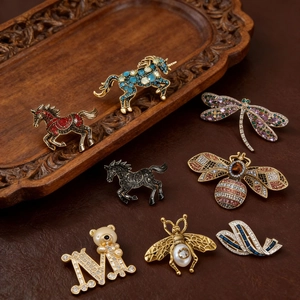 Macro detail of vintage horse and insect brooches with rhinestones on a leather background