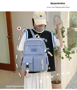 Light blue canvas backpack with multiple pockets shown on model against a simple wall