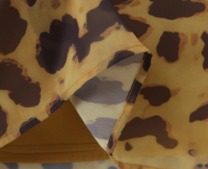 Detail shot of leopard print fabric showing fine stitching and lightweight texture