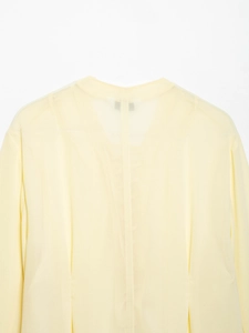 Detail of light yellow sheer fabric and round neckline on a summer fashion blouse