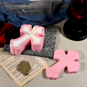Gotische Kerzen in Kreuzform in Rosa und Weiß auf Vintage-Schieferplatte mit Rosen