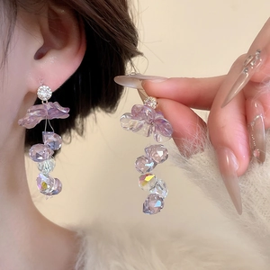 Close-up of lavender flower earrings with faceted crystals and sparkling pavé diamonds