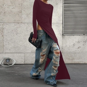 Detail eines weinroten Langarmshirts mit hohem Seitenschlitz und zerrissener Jeans