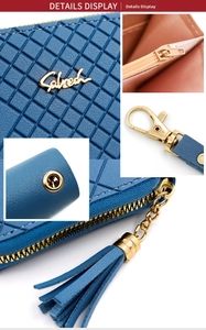 Detail of dark blue quilted wallet with tassel zipper and golden metal hardware