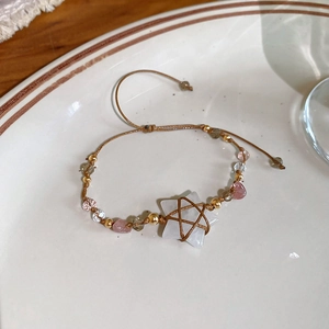 Detailed macro view of bohemian hand-woven star crystal stone bracelet with gold beads