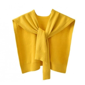 Detail shot of a yellow knitted shawl tied in a knot showing fine needlework texture