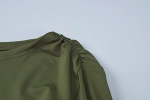 Detail view of military green dress showing shoulder pleats and double-needle stitching