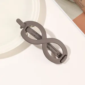 Detailed close-up of a matte brown infinity-shaped hair claw with frosted resin finish
