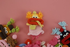 Close-up of hand-knitted pink monster key case with detailed crochet stitch texture