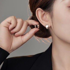 Polished silver heart hoop earrings for women in a vintage minimalist style on model