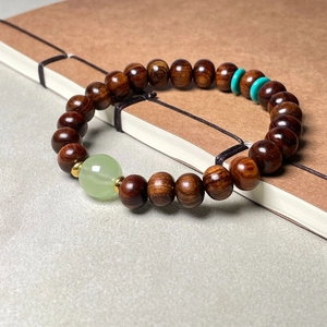 Bracelet classique en bois de santal avec perle de jade verte sur livre ancien