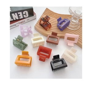 Flat lay of medium square hair claws in eleven varied matte and gloss colors