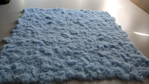 Detailed texture of thick artificial moss turf with light blue plush fiber surface