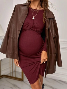 Detail of burgundy maternity knit dress with front twist knot design and long sleeves