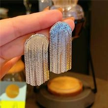 Detail shot of silver long tassel drop earrings with sleek semi-circle metal plates