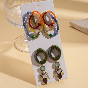 Detail of bohemian earrings set with colorful glass beads and sparkling rhinestones