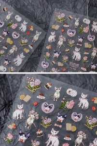 Macro detail of 3D embossed nail art stickers featuring cute cats and tulip patterns