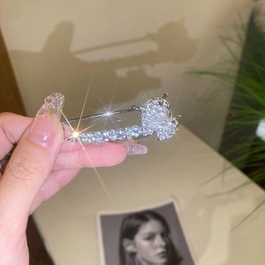 Detail of silver safety pin brooch with sparkling crystals and bear-shaped zircon design