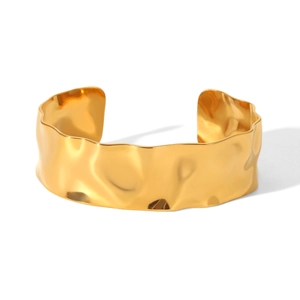 Bracelet jonc doré minimaliste avec une texture martelée unique sur un fond blanc